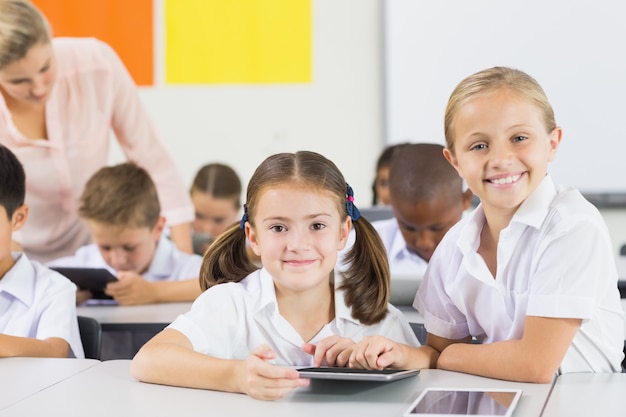 Crianças da escola usando tablet digital em sala de aula