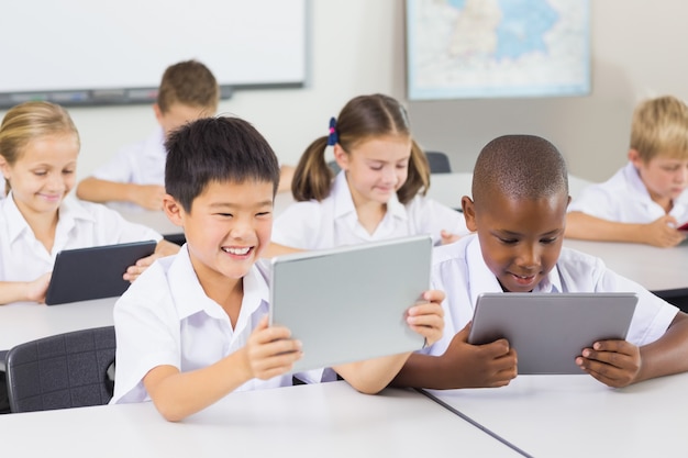 Crianças da escola usando tablet digital em sala de aula