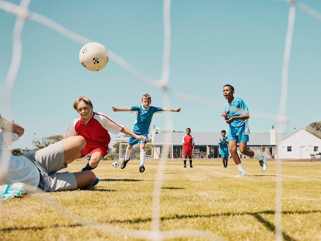 Crianças de futebol e esportes com um time de meninos jogando um jogo em um campo de grama ou campo para competição ou diversão Fitness de futebol e treinamento com crianças ao ar livre para jogar uma partida esportiva competitiva