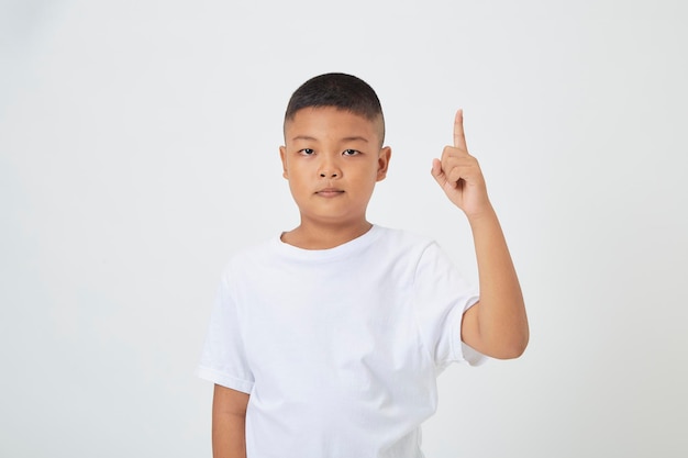 Crianças de menino vestindo uma camiseta casual de pé isolado fundo branco