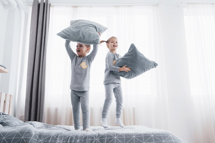 Foto crianças de pijama macio e quente brincando na cama