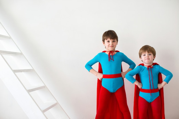 Crianças de super-heróis engraçados brincando de super-heróis isolados