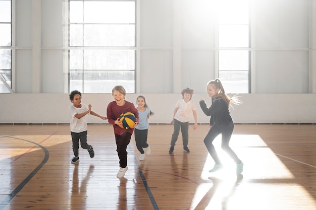 Crianças de tiro completo jogando basquete juntos