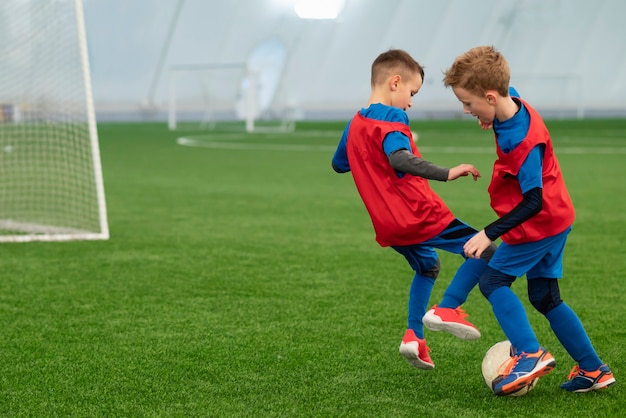 Foto crianças de tiro completo jogando futebol