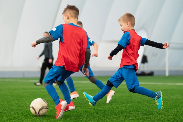 Foto crianças de tiro completo jogando futebol