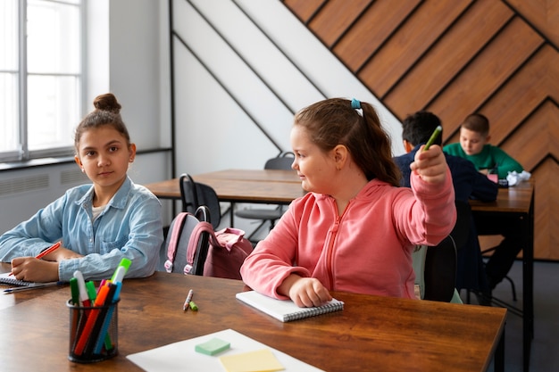 Crianças de tiro médio aprendendo na escola