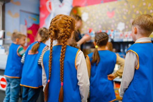 Crianças de uniforme brincando de vendedor