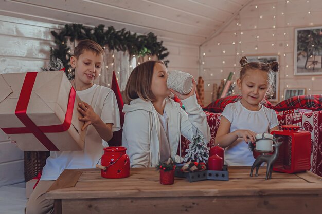 Crianças decorando a árvore de Natal Feliz Natal e feriados de ano novo Férias de inverno em família e conceito de pessoas Família amorosa de retrato de perto