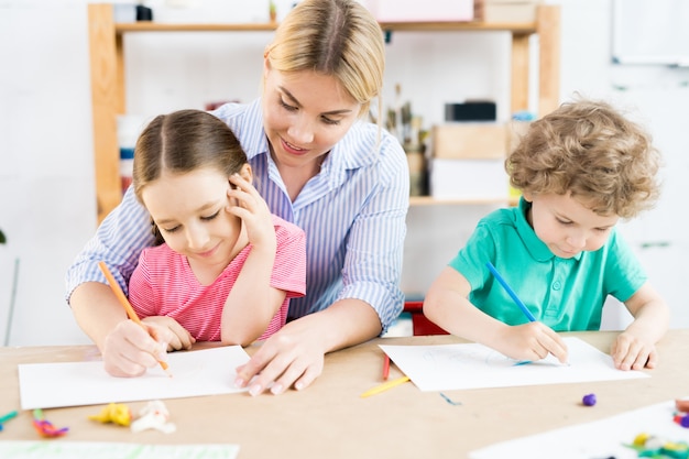 Crianças desenhando com mãe