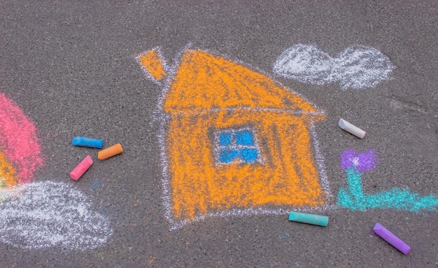 Crianças desenhando na casa da família de asfalto