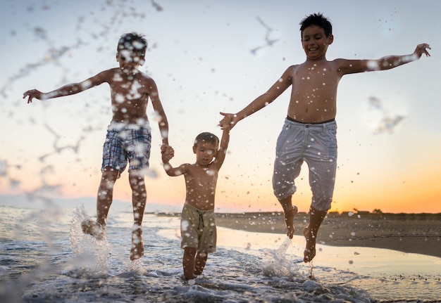 Crianças divertidas jogando splash na praia