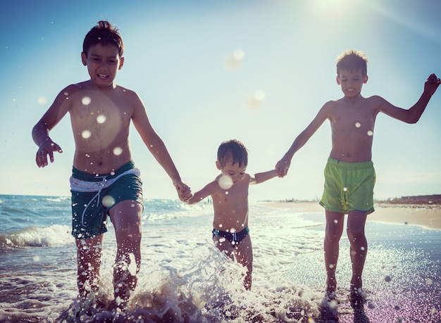 Crianças divertidas jogando splash na praia