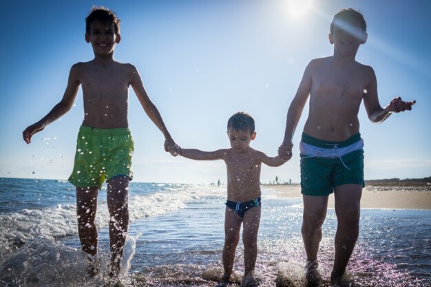 Crianças divertidas jogando splash na praia