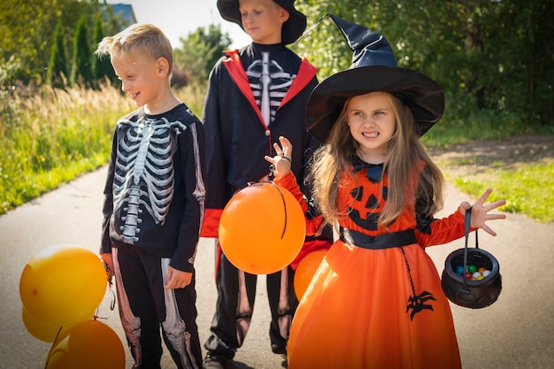 Crianças do Halloween vão coletar doces, truque ou trato, disfarçando crianças jackolantern no carnaval