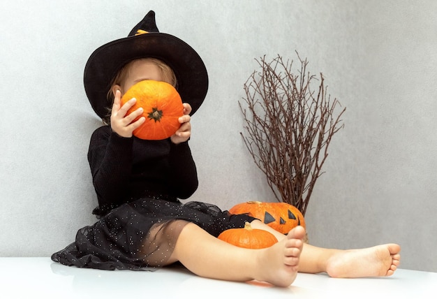 Crianças doces ou travessuras Criança com fantasia de Halloween se divertindo com abóbora