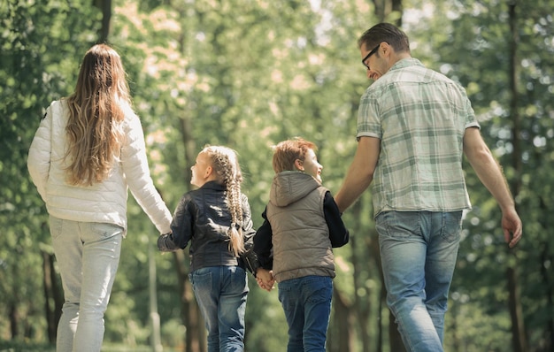 Crianças e pais em uma caminhada no parqueo conceito de entretenimento familiar