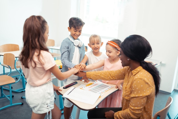 Crianças e professores desfrutando de seu trabalho em equipe todos juntos