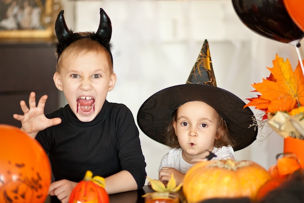 Crianças em fantasias de bruxa e demônio para o Halloween