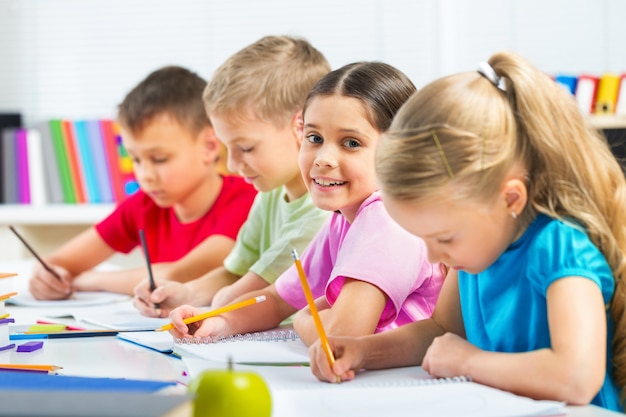 Crianças em idade escolar, escrevendo, desenhando