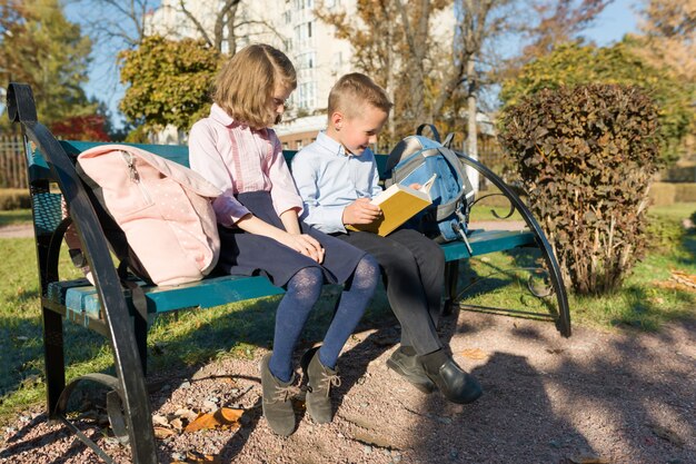 Crianças em idade escolar menino e menina lendo livro