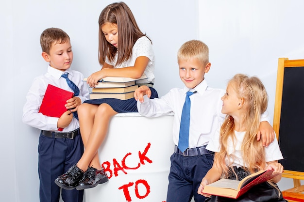 Crianças em idade escolar meninos e meninas felizes lindas em um fundo branco de volta às aulas