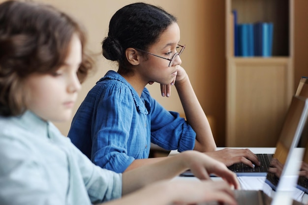 Crianças em idade escolar trabalhando em computadores em sala de aula