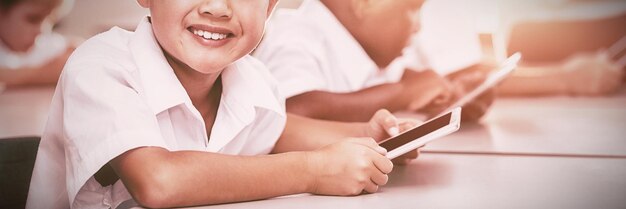 Crianças em idade escolar usando telefone celular na sala de aula