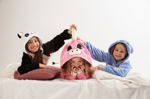 Foto crianças em pijamas quentes e macios fazendo festa coloridas alegres brincando em casa