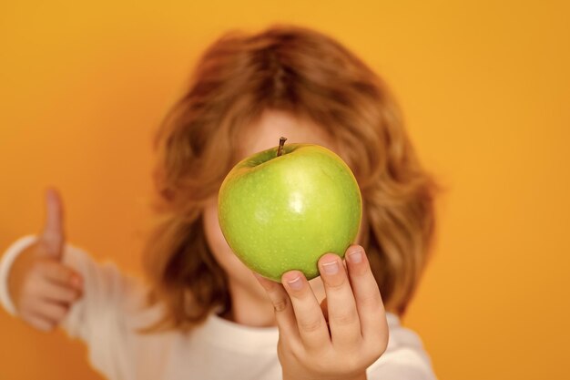 Crianças enfrentam frutas com maçã em estúdio, retrato de criança fofa segurando maçã isolada em