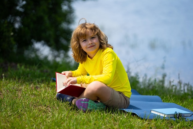 Crianças espertas, crianças fofas, leem livros ao ar livre, crianças aprendendo e educação de verão, meninos lendo