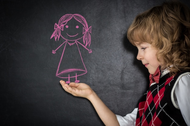 Foto crianças espertas na sala de aula. crianças felizes contra o quadro-negro. conceito de educação