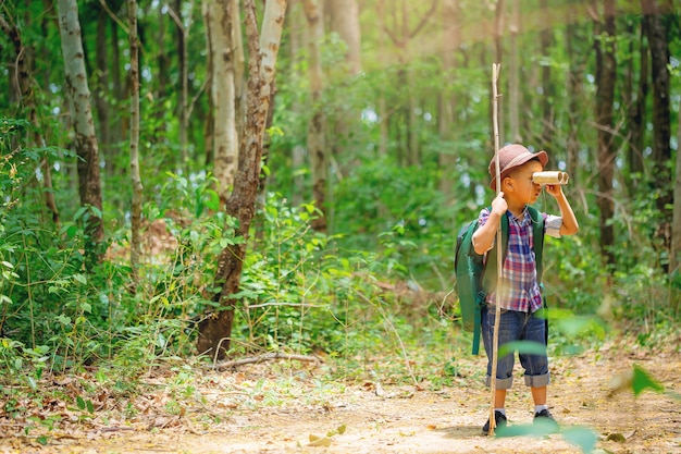 Crianças fazem caminhadas no quintal com mochilas no caminho da floresta explorer e aventura com binóculo de brinquedo