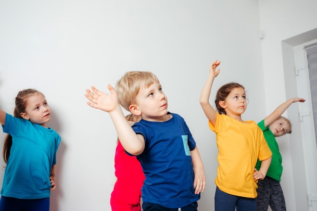 Crianças fazendo exercícios de alongamento antes do treino de ginástica