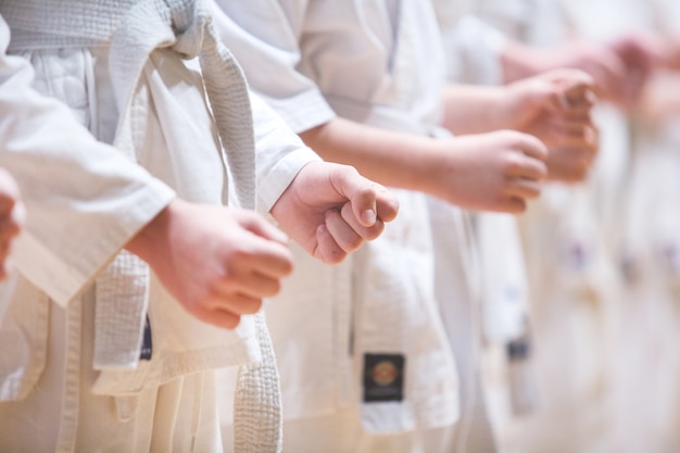 Crianças fecham os punhos durante o treino de caratê