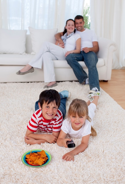 Crianças felizes assistindo televisão no chão na sala de estar