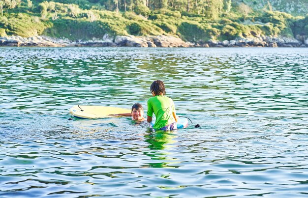 Crianças felizes brincando no mar. Crianças se divertindo ao ar livre. Conceito de férias de verão e estilo de vida saudável.