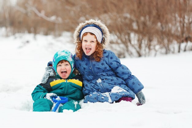 Crianças felizes brincando no parque de inverno.