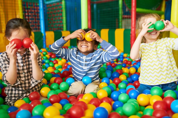 Foto crianças felizes brincando no poço da bola