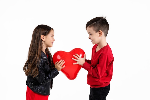 Crianças felizes com balão de coração vermelho