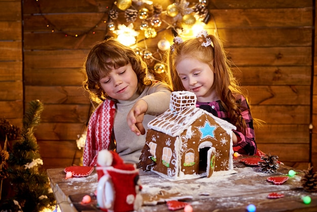 Crianças felizes criam pão de gengibre de Natal.