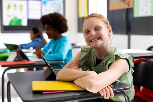 Foto crianças felizes e diversas sentadas em mesas em salas de aula