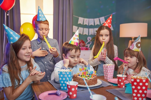 Crianças felizes em bonés de festa comemorando um aniversário