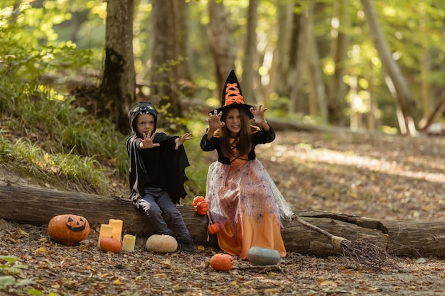 Crianças felizes em fantasias de Halloween se divertindo em decorações de Halloween ao ar livre Feliz Halloween