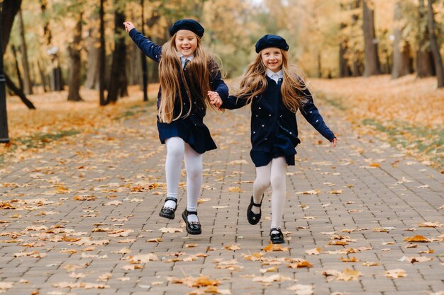 Crianças felizes estão correndo em um belo parque de outono