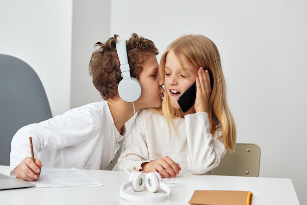 Crianças felizes estudando on-line em casa usando laptops e fones de ouvido os dois irmãos um menino e um