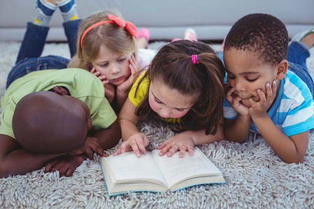 Crianças felizes lendo um livro juntos