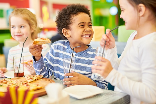 Foto crianças felizes na pizzaria