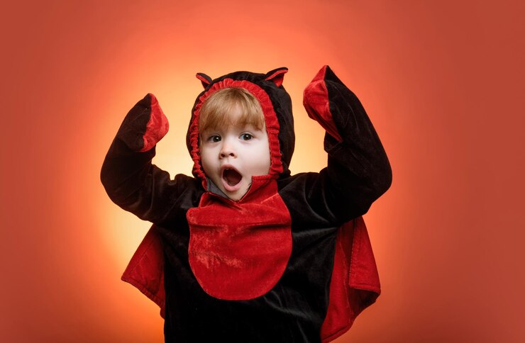 Foto crianças felizes no halloween crianças engraçadas em trajes de carnaval em fundo laranja rostos assustadores rostos horríveis rostos engraçados crianças na américa celebram o halloween