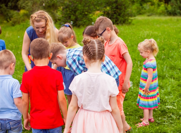 Crianças felizes se divertindo juntos na natureza no parque de verão