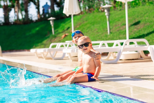 Crianças felizes se divertindo na piscina do resort de férias